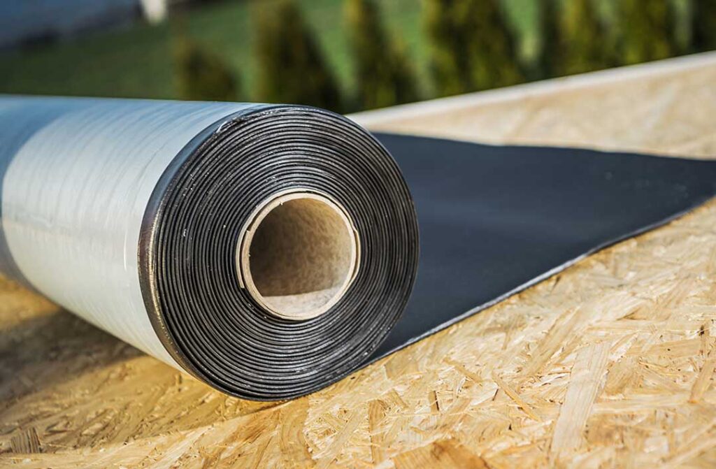 Roofing samples with rating labels beside a sunlit residential attic and insulation materials.